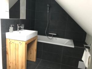 a bathroom with a sink and a bath tub at A Ház in Miskolc
