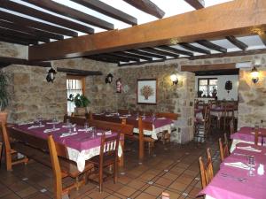 a restaurant with tables and chairs with purple tablecloths at Posada Maximo in Espinama