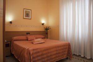 a bedroom with a bed with a orange blanket at Casa La Salle - Casa Religiosa in Rome
