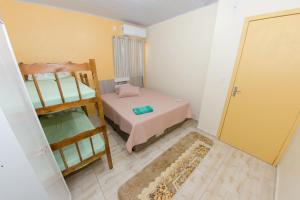 Habitación pequeña con 1 cama y 1 litera en Pousada Família Cordeiro en Penha