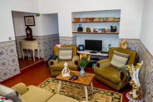 a living room with two chairs and a desk at Quintal d'Angra in Angra do Heroísmo