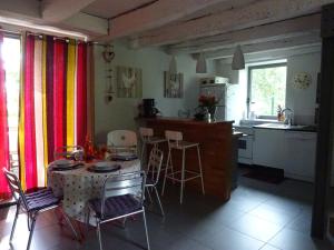 a kitchen with a table and chairs and a kitchen with a counter at Gîte au Martin Pêcheur in Laiz