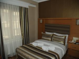 A bed or beds in a room at Alfa Hotel