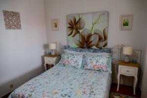 1 dormitorio con 1 cama con una planta en la pared en Quintal d'Angra, en Angra do Heroísmo