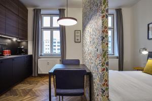 a bedroom with a bed and a table and a kitchen at Cosy Design Apartment II in Brno