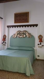 a bedroom with a green bed with two lamps at Piccolo appartamento a San Marco in Venice