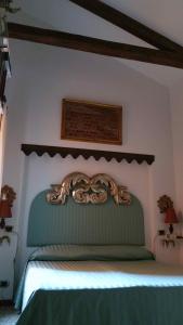 a bedroom with a green bed with a ornate headboard at Piccolo appartamento a San Marco in Venice