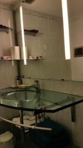 a bathroom with a glass sink and a mirror at Piccolo appartamento a San Marco in Venice