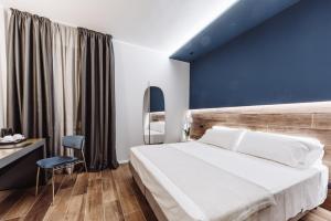 1 dormitorio con 1 cama grande y pared azul en Hotel Europa, en Chivasso