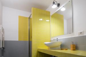 żółta łazienka z umywalką i lustrem w obiekcie Casa Magà w mieście Neapol +37 zdjęć