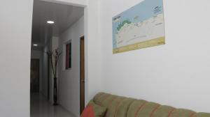 a living room with a couch and a map on the wall at Puerto Caribe Hostal in Guachaca