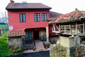 a red house with a red roof at Casa Rural Ofelia in Cudillero