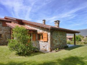 una pequeña casa de piedra con un patio de césped en Casa PereCampelles - Vall de Núria - Ripollès, en Campelles