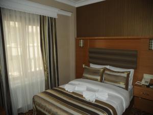 A bed or beds in a room at Alfa Hotel