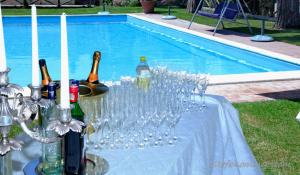 a table with wine bottles and glasses next to a pool at Parco delle Nazioni - Relax Grand Resort in Castel di Decima
