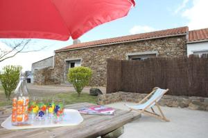 una mesa de picnic con una sombrilla roja y una silla en Le Bois Regnier, en Saint-Père-en-Retz