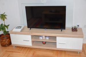una TV a schermo piatto su un centro di intrattenimento bianco di Apartman MAŠA a Banja Luka Altre 8 foto