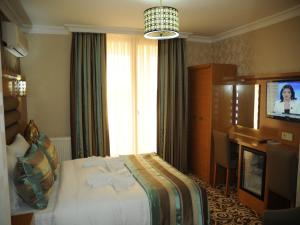 A television and/or entertainment centre at Alfa Hotel