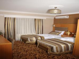 A bed or beds in a room at Alfa Hotel