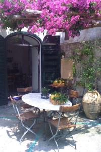 einen Tisch mit Stühlen und einen Tisch mit Blumen in der Unterkunft Casa Giardino in Positano