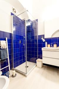 a bathroom with a shower with blue tiles at Casa Giardino in Positano