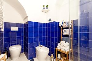 ein blau gefliestes Bad mit einem WC und einer Dusche in der Unterkunft Casa Giardino in Positano