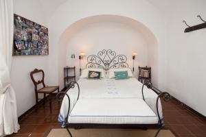 ein Schlafzimmer mit einem weißen Bett in einem Zimmer in der Unterkunft Casa Giardino in Positano