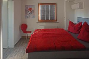 a bedroom with a red bed and a red chair at FeWo „Zum Napoleonstein“ in Dresden