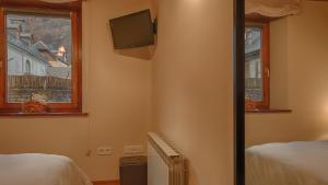 a bedroom with two beds and a tv and two windows at Saplan Real Estate CASISH in Les