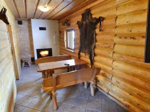 Zimmer mit einer Holzwand mit Bänken und einem Kamin in der Unterkunft Domek Na Stoku in Korbielów