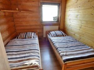 two beds in a log cabin with a window at Domek Na Stoku in Korbielów