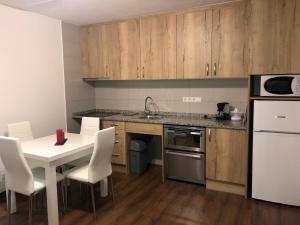 a kitchen with a white table and white chairs at LAKE PLACID 605 in Pas de la Casa