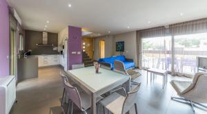 eine Küche und ein Wohnzimmer mit einem Tisch und Stühlen in der Unterkunft Villa Marianna in L'Escala