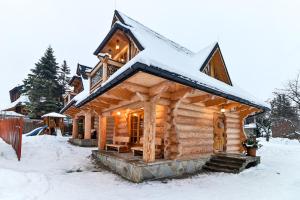 eine Blockhütte mit Schnee auf dem Dach in der Unterkunft Przytulny Domek I in Zakopane