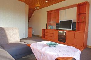 a living room with a couch and a tv and a table at Ferienwohnung mit Wasserbett FW3 in Saalfeld