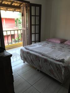 1 dormitorio con 1 cama y puerta que da a un patio en Casa Praia Rasa, en Búzios