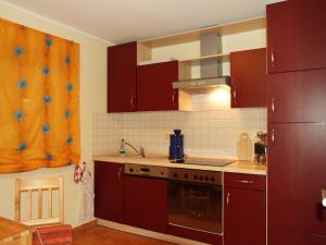 a kitchen with brown cabinets and a stove top oven at Ferienhaus Am Seeufer in Waren