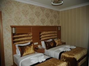 A bed or beds in a room at Alfa Hotel