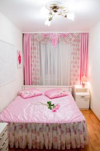 ヨシュカル・オラにあるулица Кирова дом15のベッドルーム1室(花の飾られたピンクベッド1台付)