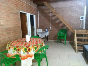 a room with a table and green chairs at La Tribu in Paso de la Patria