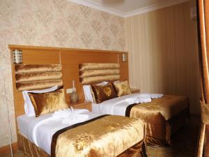 A bed or beds in a room at Alfa Hotel