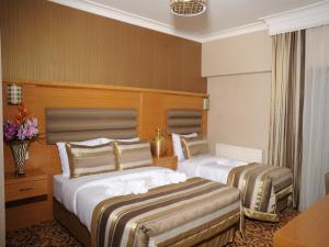 A bed or beds in a room at Alfa Hotel