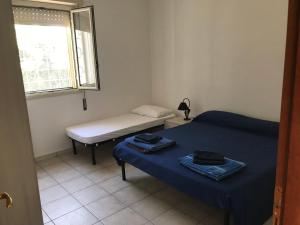mały pokój z 2 łóżkami i oknem w obiekcie Villetta San Lorenzo - Marzamemi w mieście Reitani