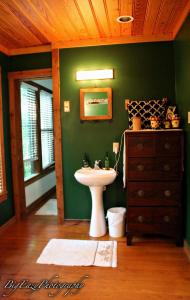 a green bathroom with a sink and a dresser at The River Chalet in Folsom
