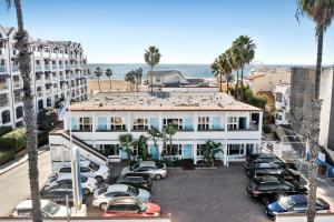 洛杉磯的住宿－海藍酒店，一座白色的大建筑,汽车停在停车场