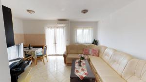 a living room with a couch and a television at Apartments Goga in Umag