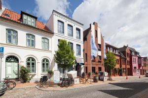 uma rua da cidade com edifícios e bicicletas estacionadas na rua em Nordsee-Hotel Hinrichsen em Husum