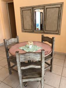 einen Esstisch mit 2 Stühlen und eine Schüssel Blumen darauf in der Unterkunft La Morada Hosteria in Capilla del Monte