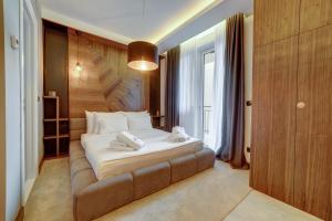 ein Schlafzimmer mit einem großen Bett und einem braunen Sofa in der Unterkunft Black Pearl Luxury Suites in Belgrad