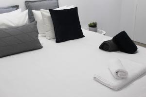 a white bed with black pillows and a keyboard on it at Olosuites in Limassol